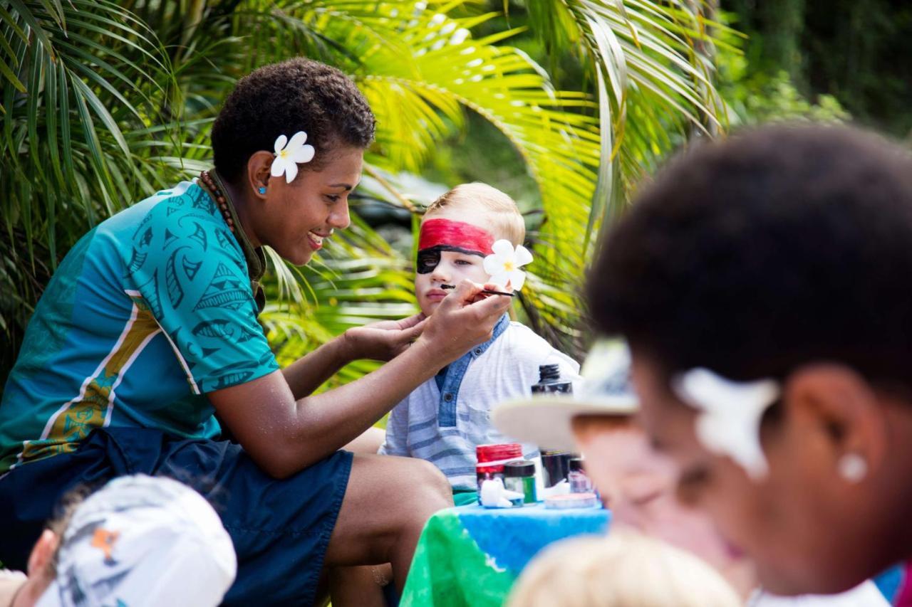 Outrigger Fiji Beach Resort Korotogo Exteriér fotografie A young woman from the Cook Islands applying titi muka to a child's face